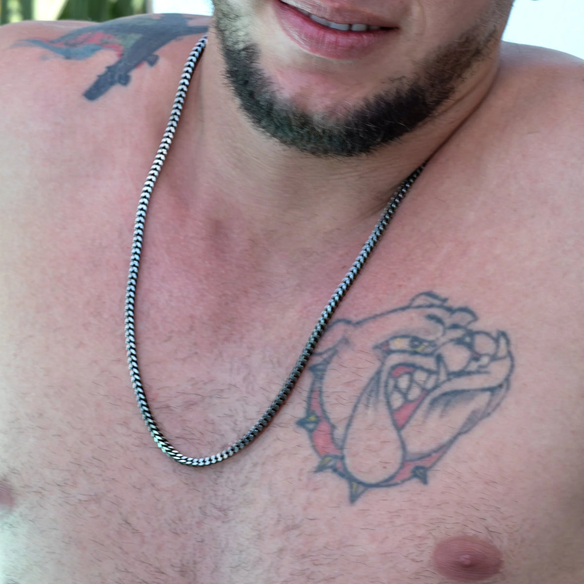 Tattoo of a bulldog’s head on a person’s chest.