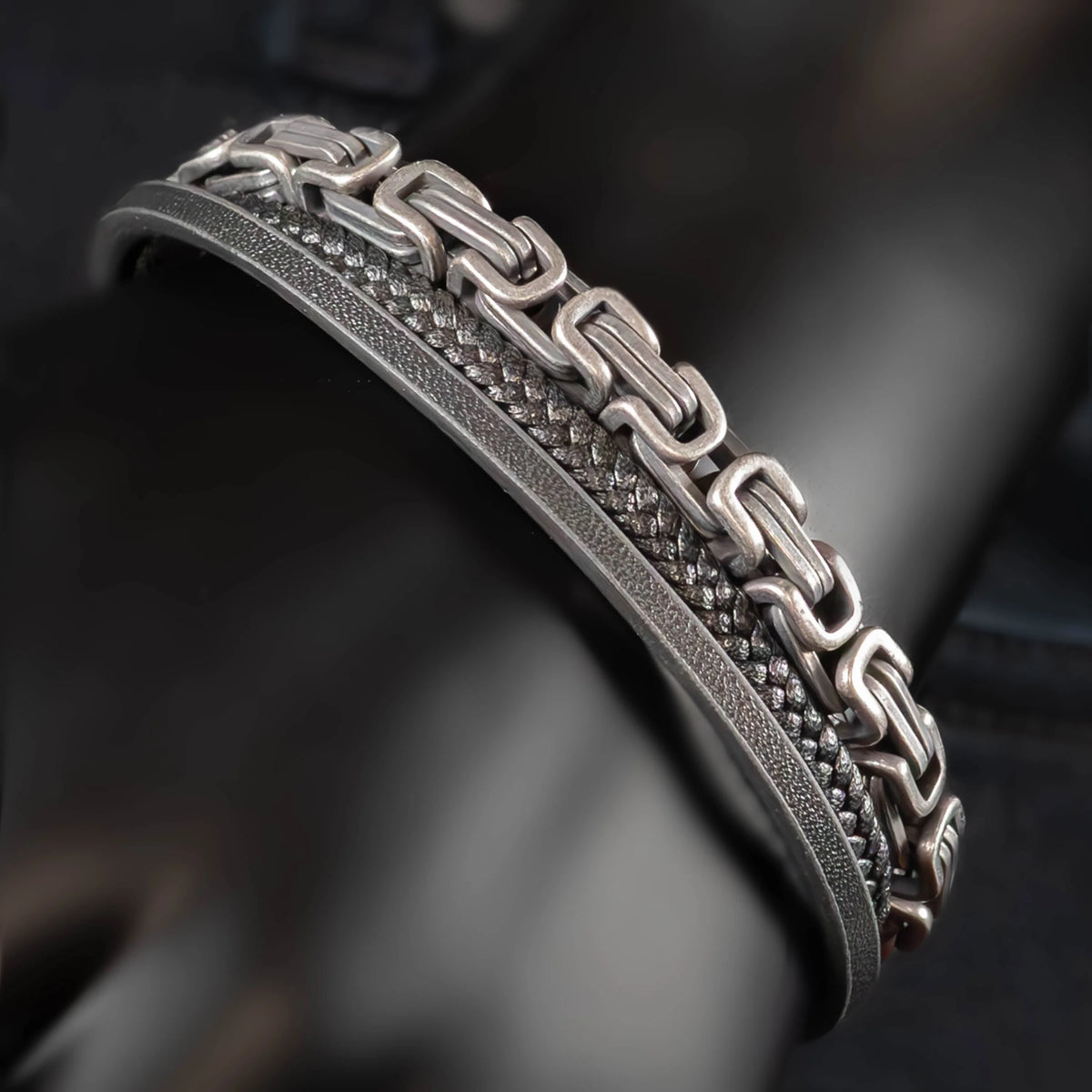 Intricately designed silver bracelet with a chain-link pattern and textured bands.