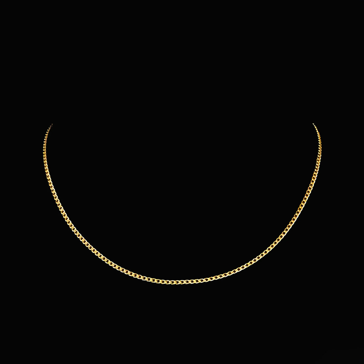 Gold chain necklace with fine links against a black background.