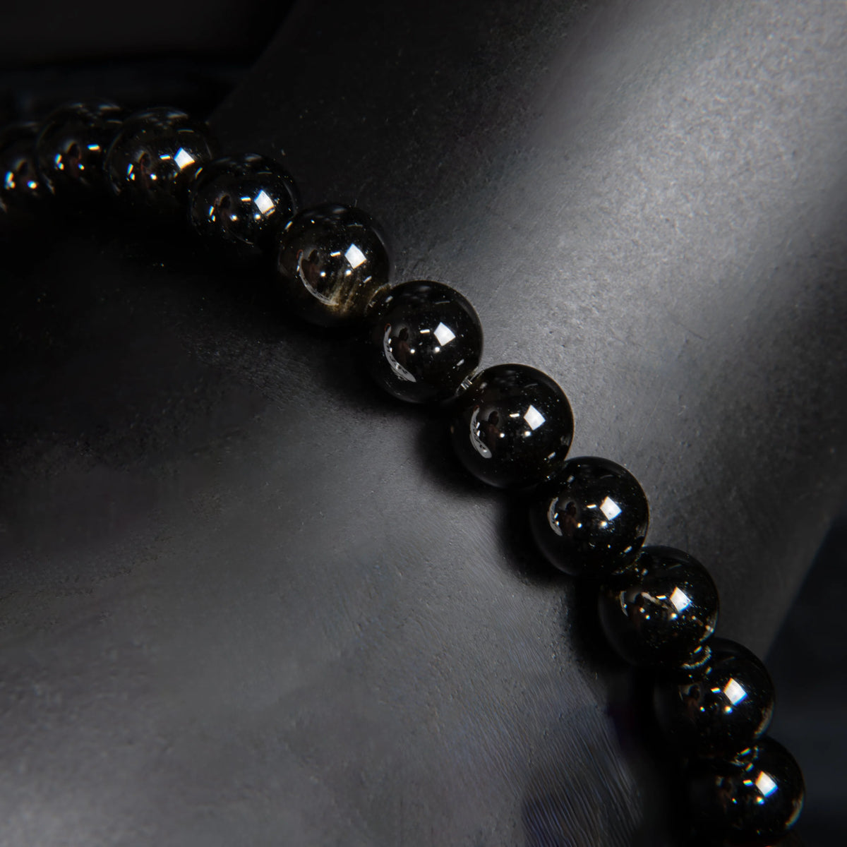 String of shiny black beads or spheres arranged diagonally.