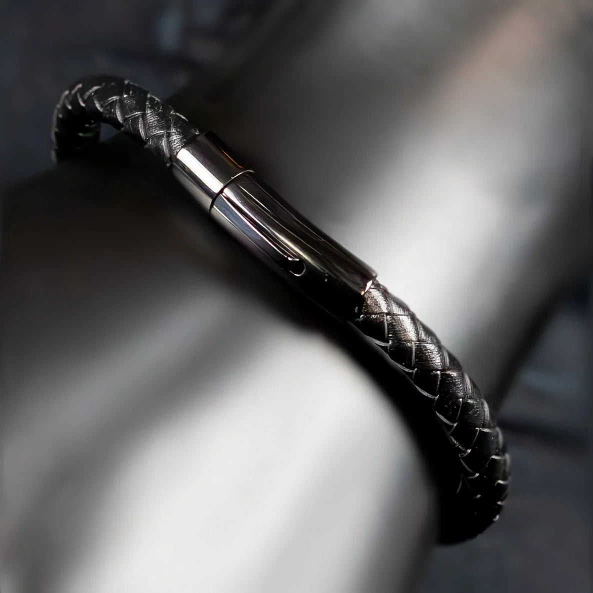 Black leather bracelet with a silver metal clasp.