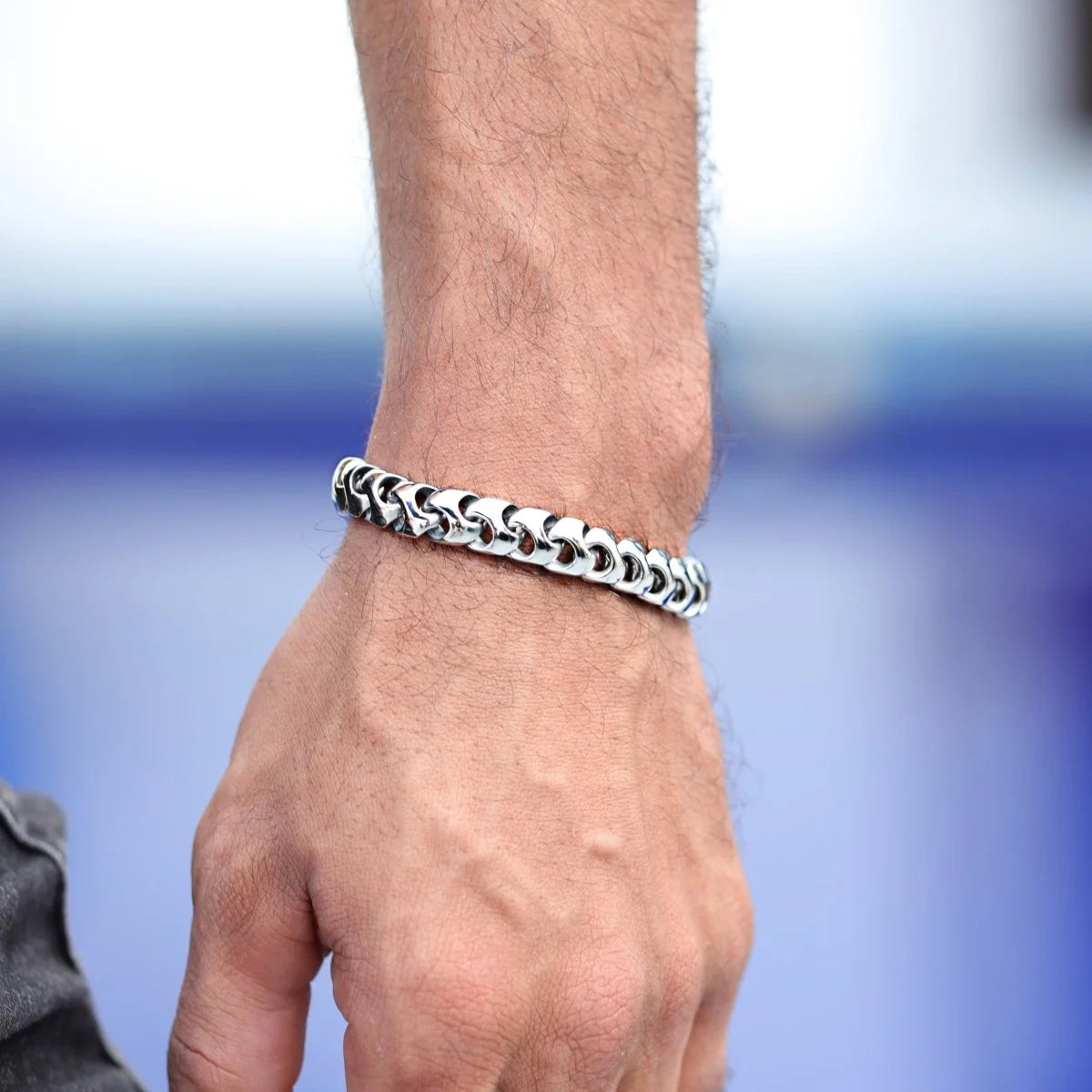 Silver chain bracelet worn on a wrist.