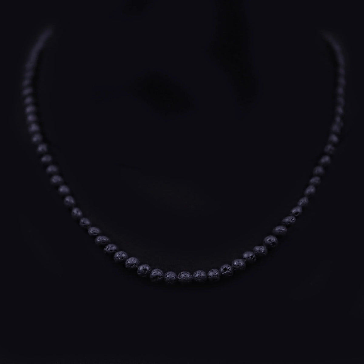 Diamond necklace with graduated stones set in a dark metal.