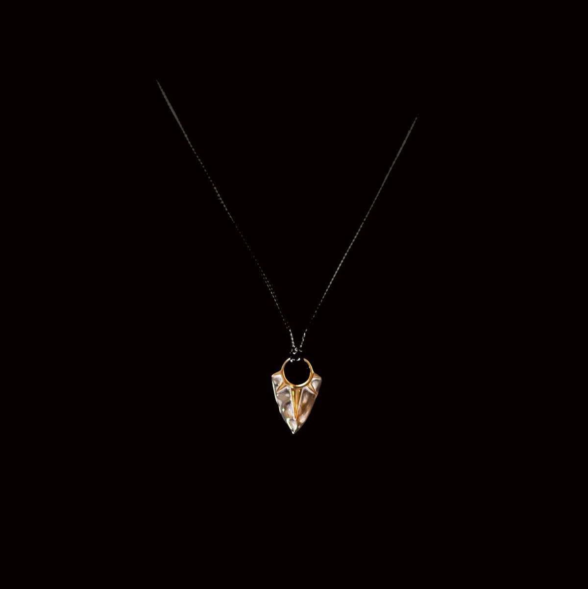 Crystal pendant necklace with a triangular-shaped charm.