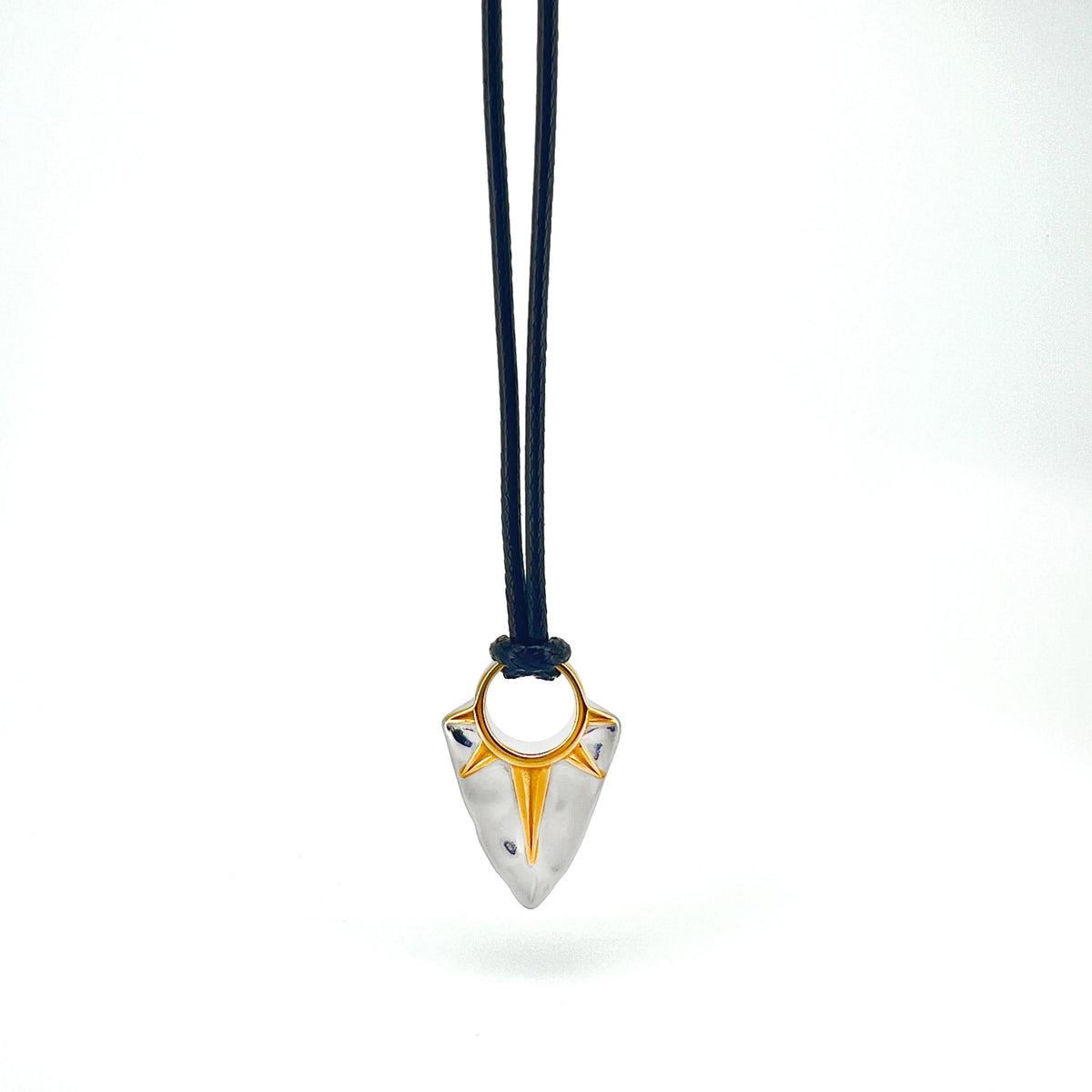 Pendant necklace with a triangular silver charm and gold accents on a dark cord.