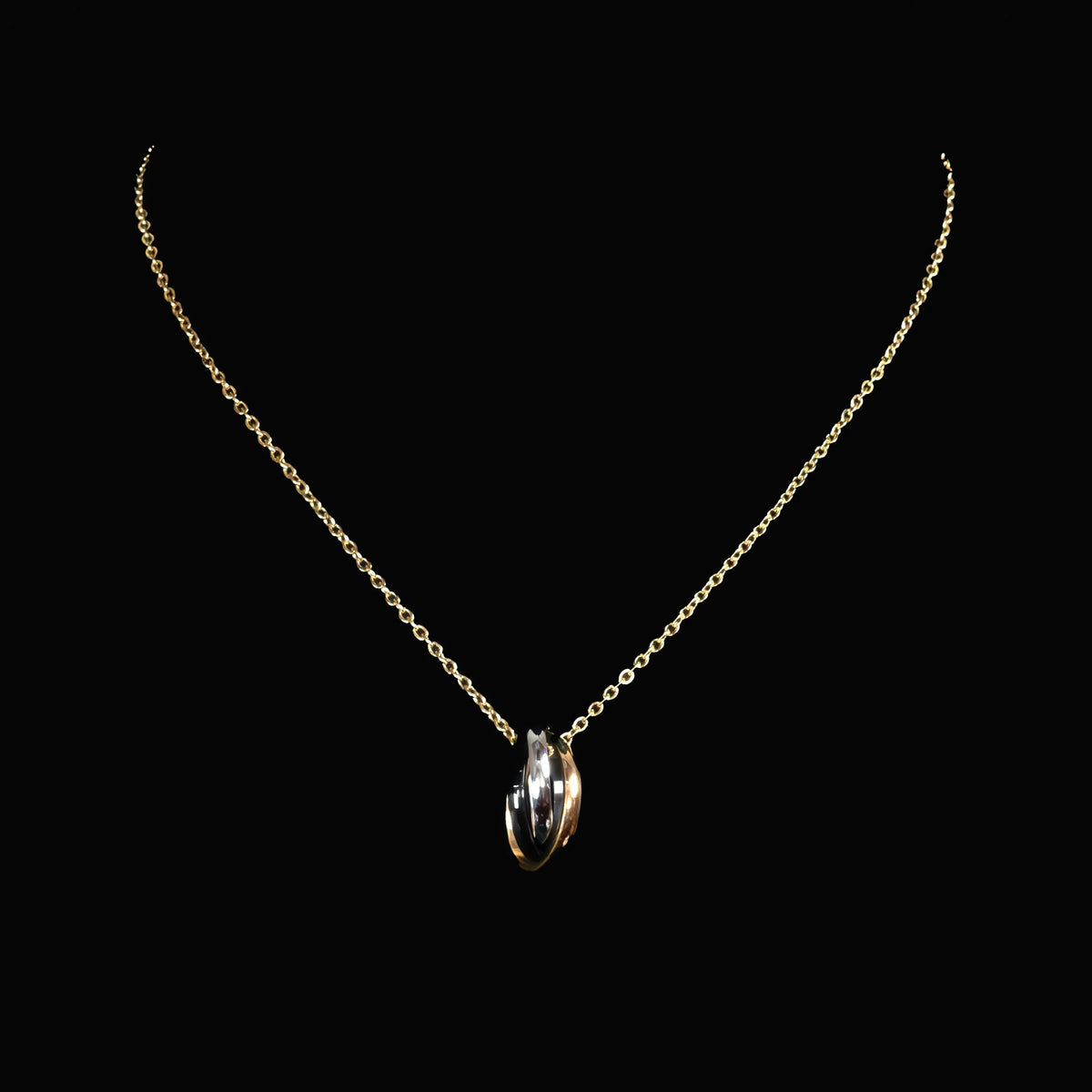 Delicate gold chain necklace with a tri-color twisted pendant.