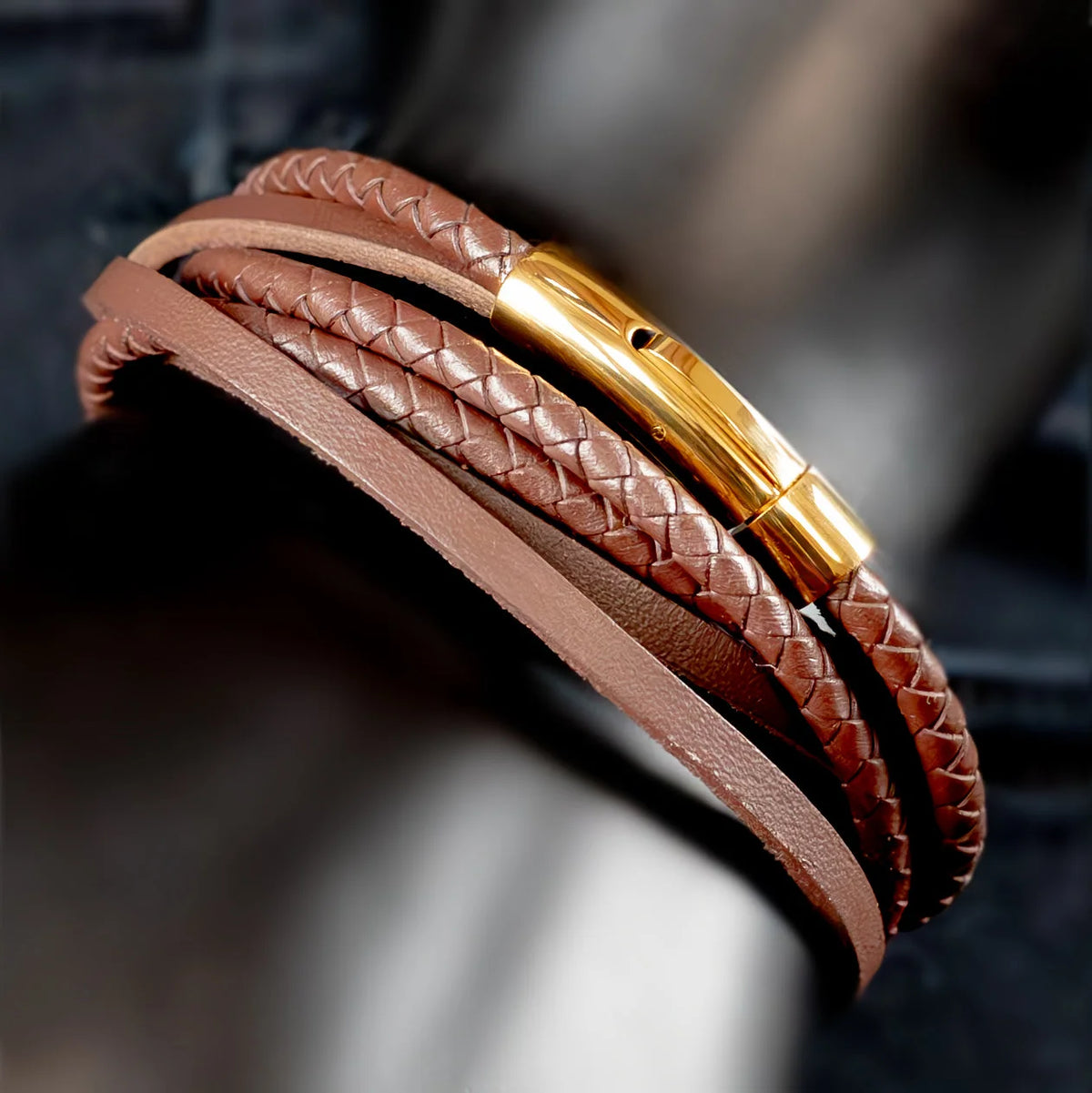 Brown leather bracelet with braided strands and a gold clasp.