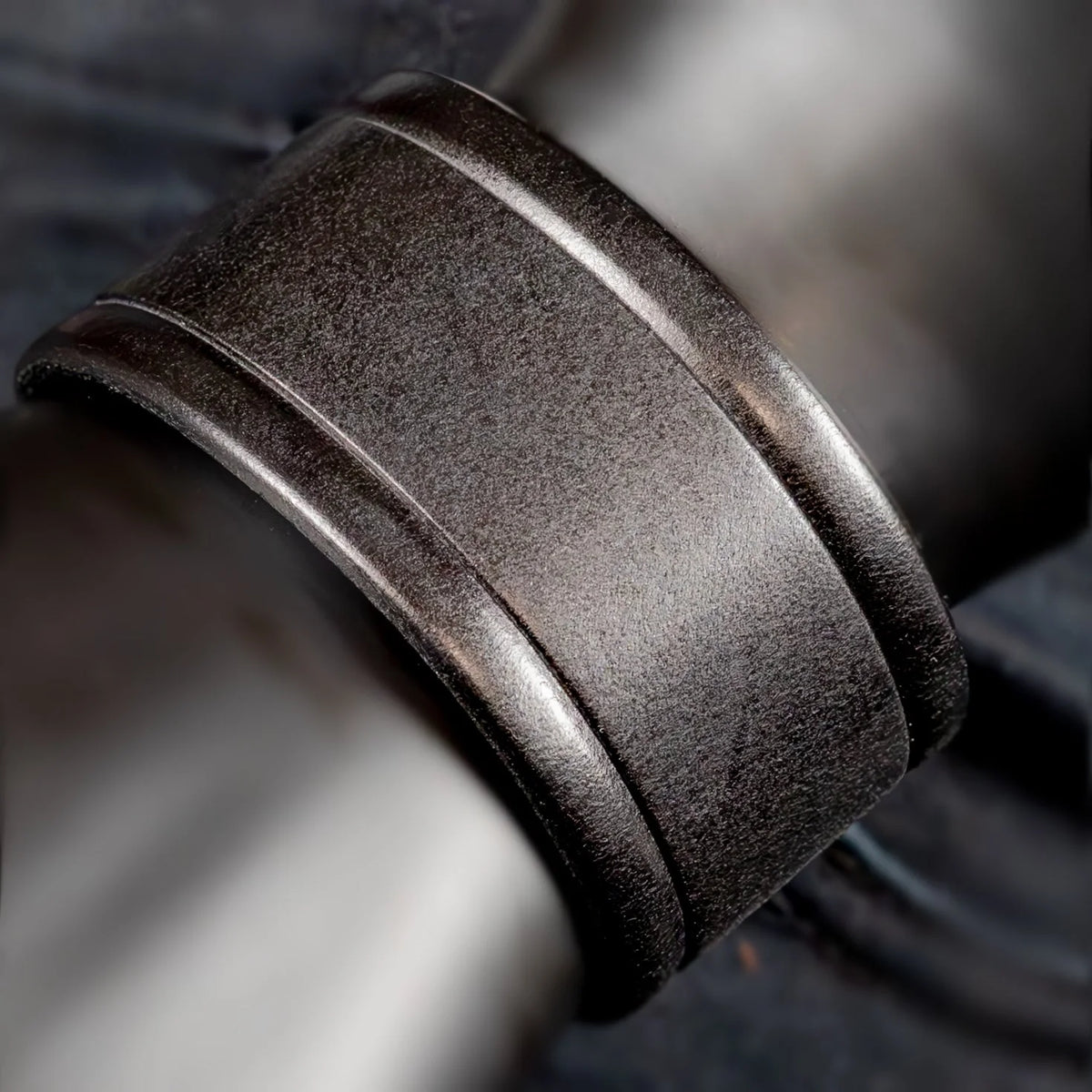 Dark metallic ring with two grooved bands around its circumference.