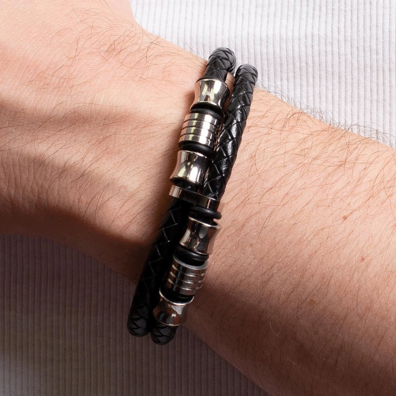 Black leather bracelet with silver metal accents worn on a wrist.