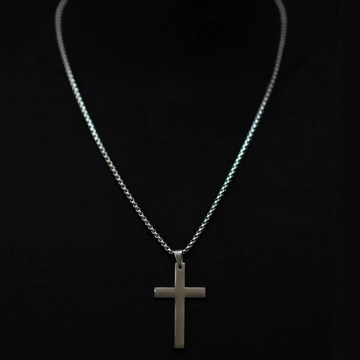 Silver cross pendant on a delicate chain necklace.