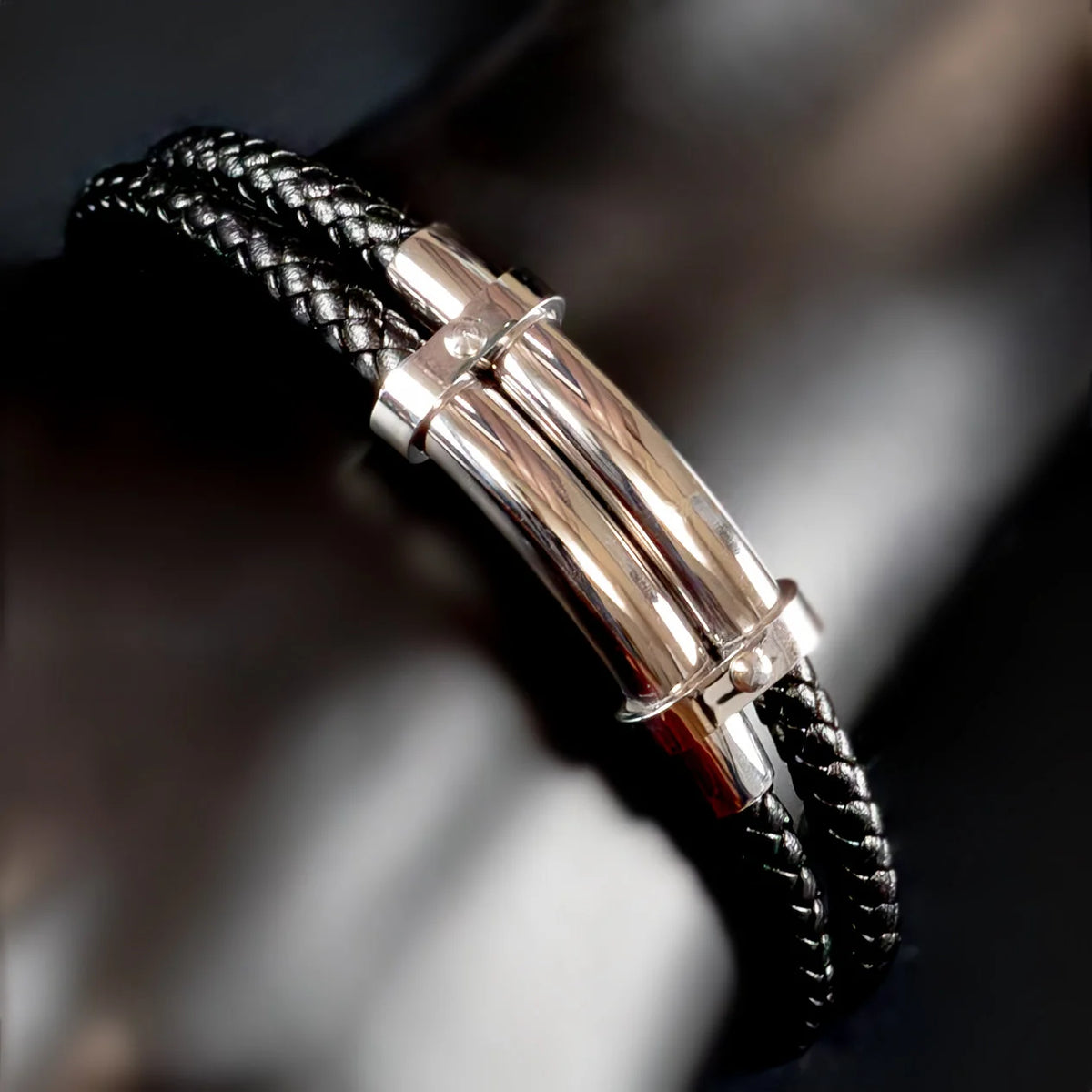 Black braided leather bracelet with a silver metal clasp.