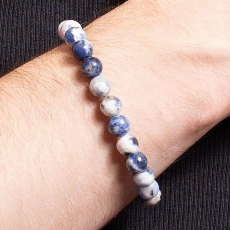 Beaded bracelet with blue and white stones worn on a wrist.