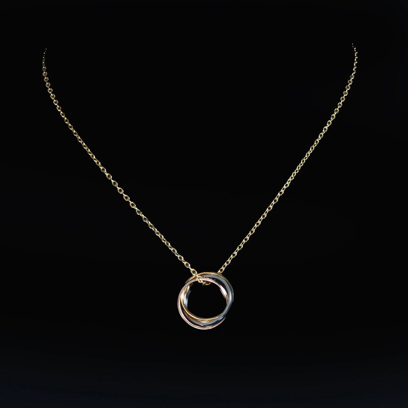 Delicate silver necklace with interlocking circular pendant.