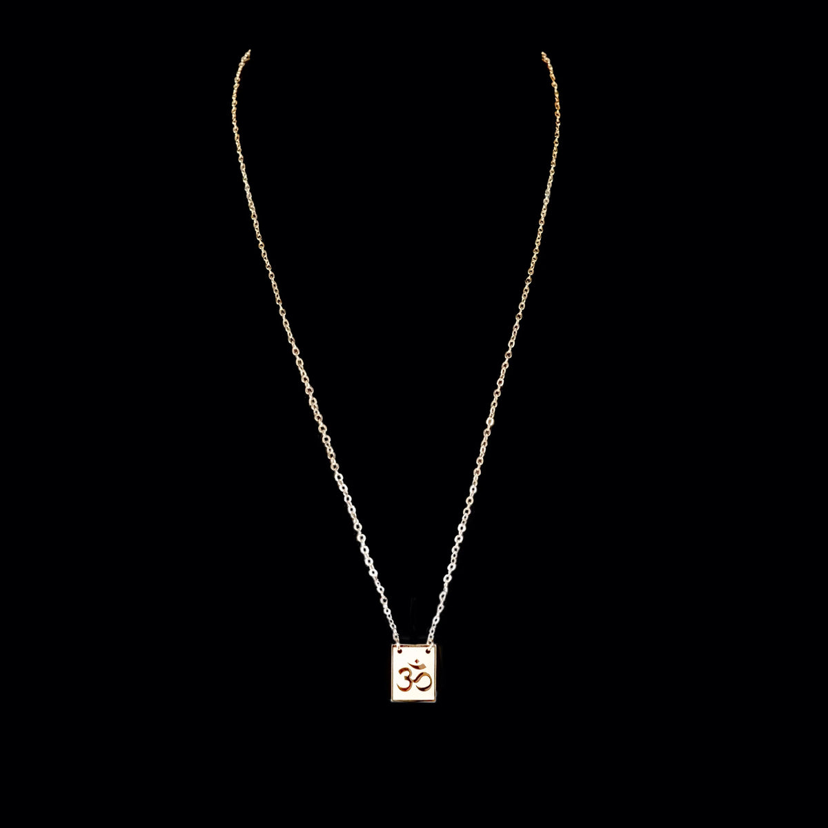 Gold necklace with a pendant featuring the Om symbol.