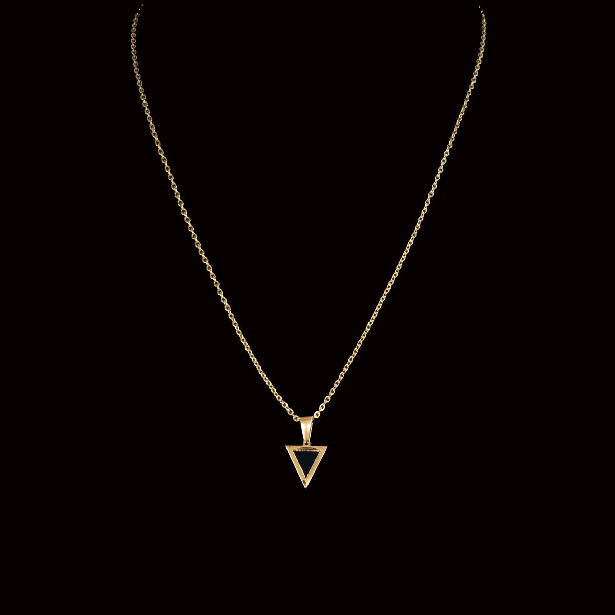 Gold necklace with a triangular pendant.