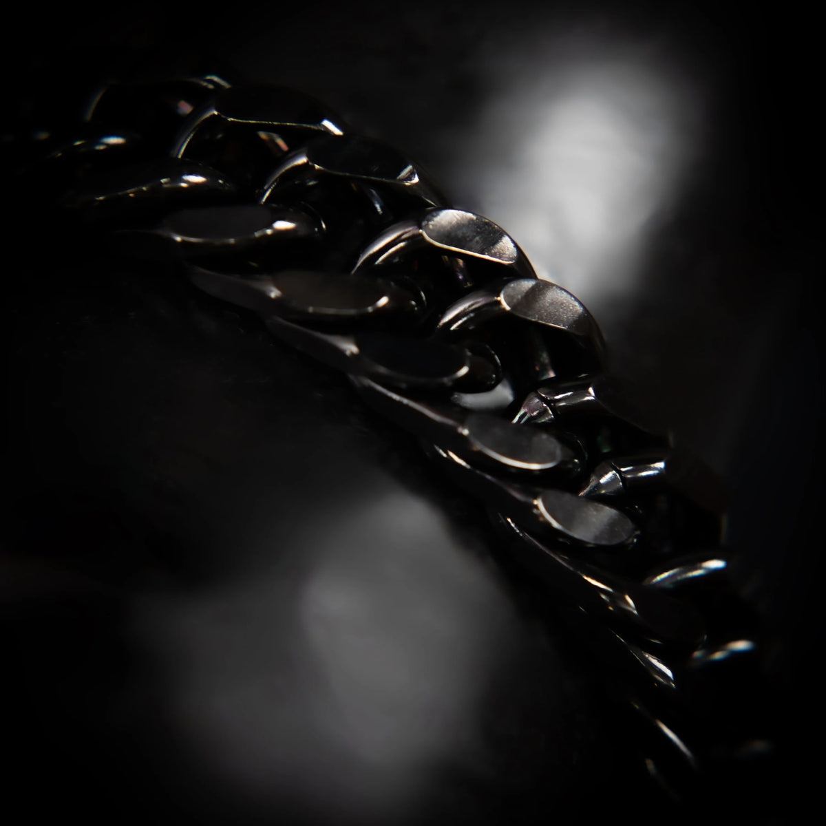 Shiny black metal chain with thick, interlocking links.