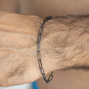 Black chain-link bracelet worn on a wrist.