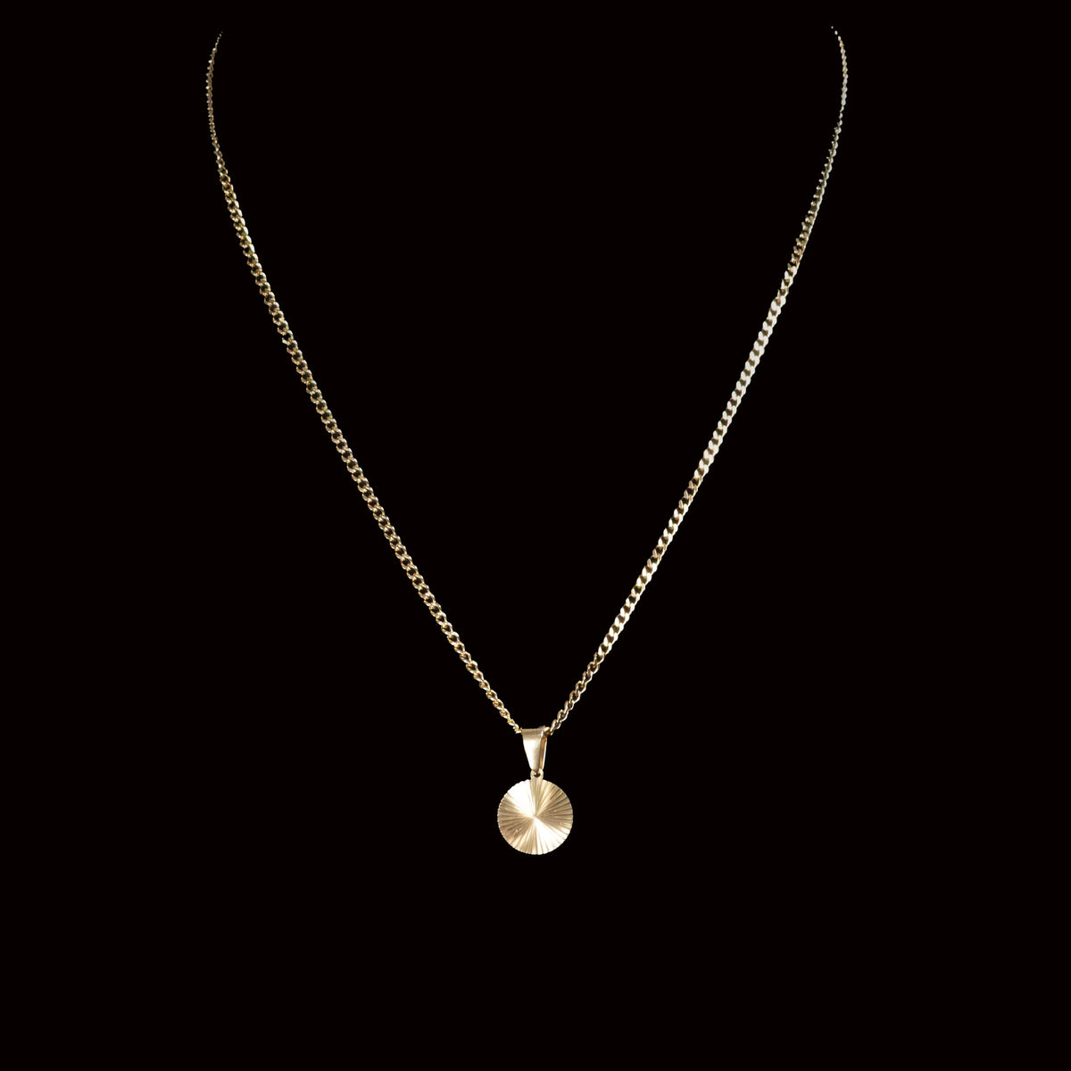 Gold necklace with a circular pendant.