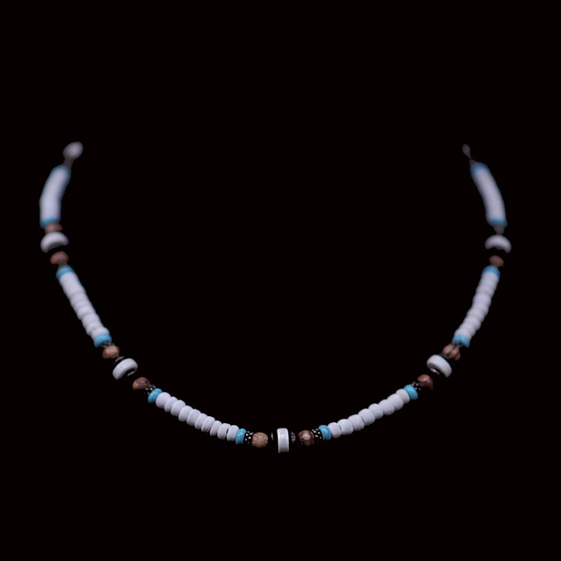 Beaded necklace with white, blue, and brown beads on a black background.