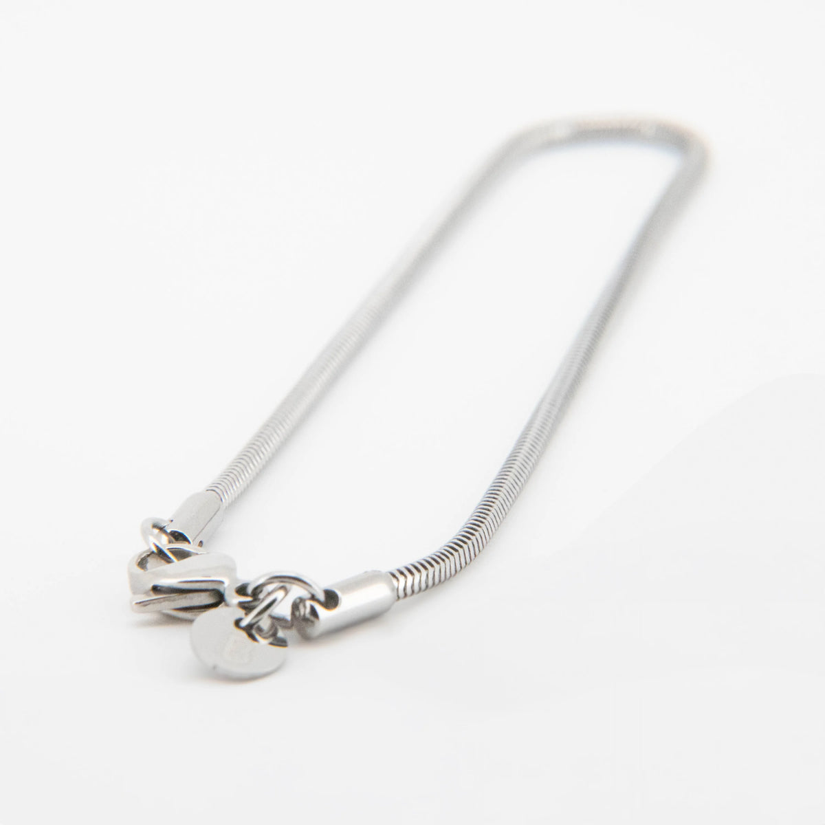 Silver snake chain necklace with heart charm.