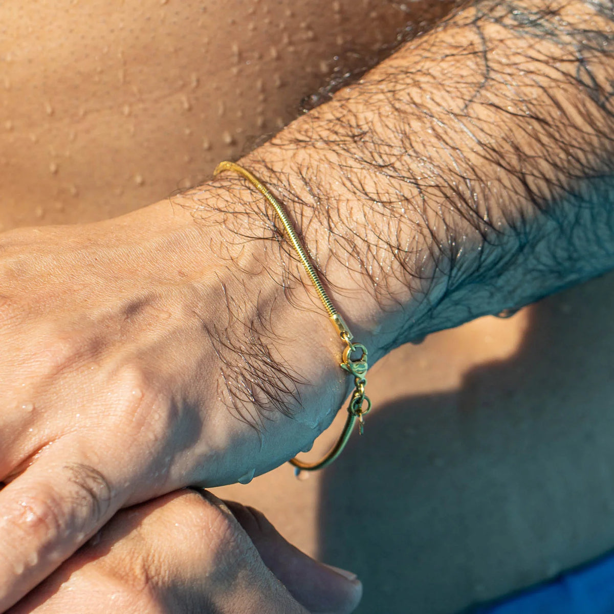 Gold bracelet with a horseshoe design worn on a wrist.