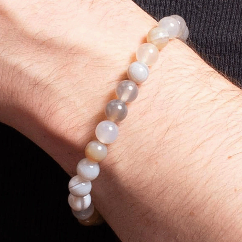 Pearl or gemstone bracelet worn on a wrist.