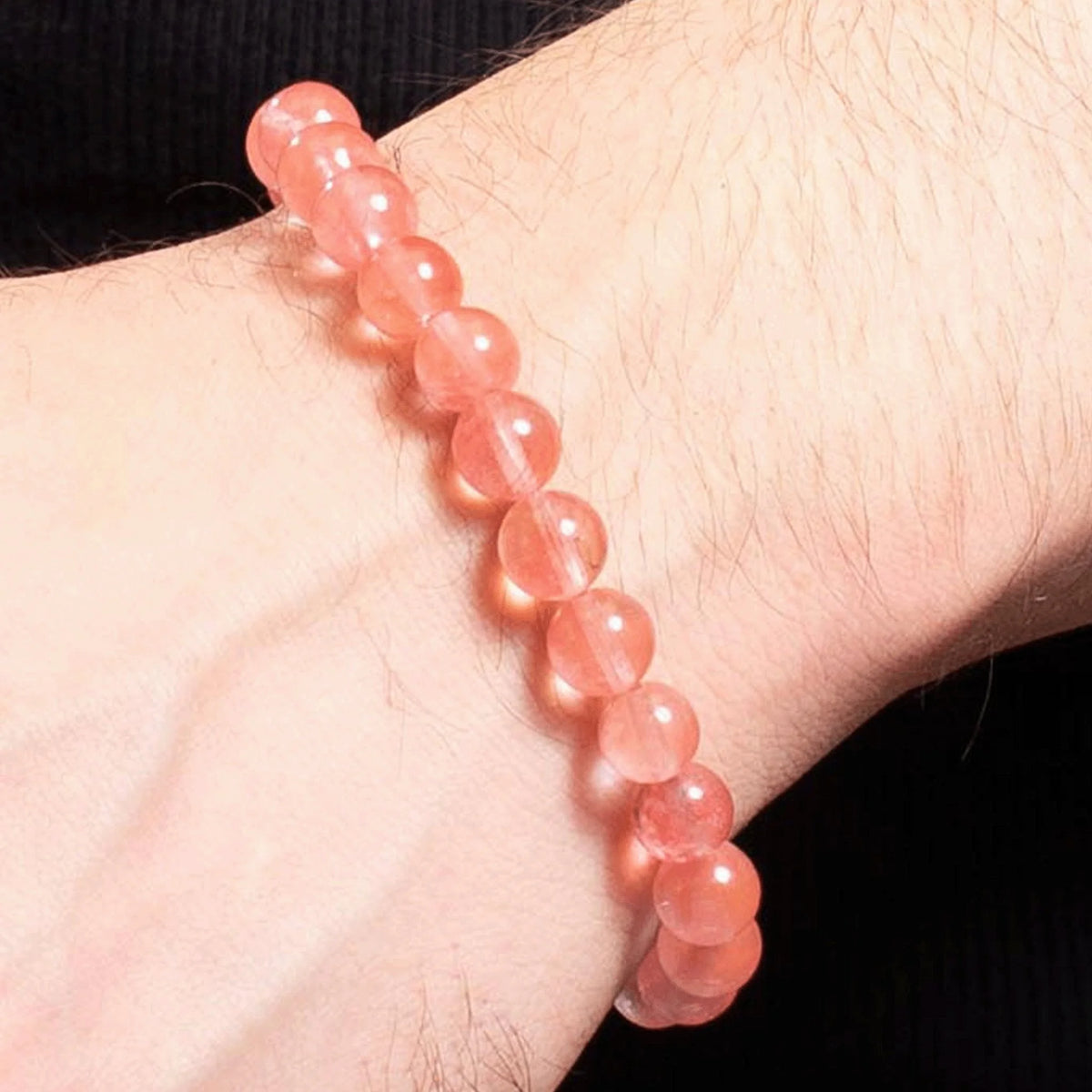 Pink gemstone or crystal bead bracelet worn on a wrist.