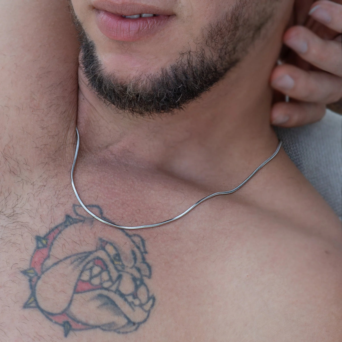 Tattoo of a bulldog’s face on a person’s chest.