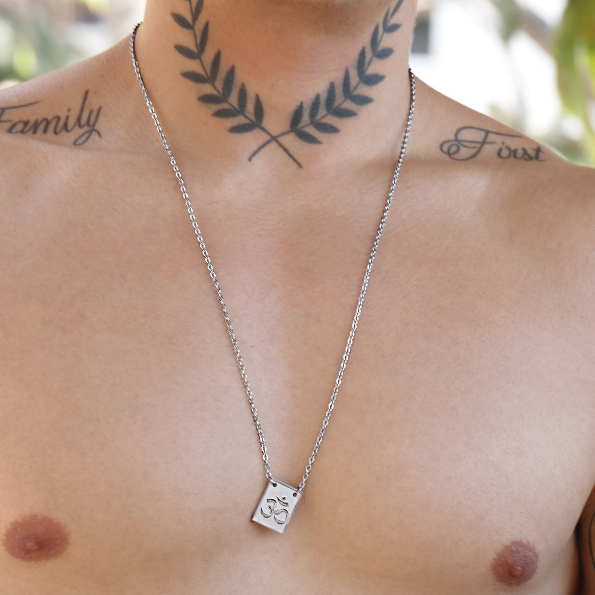 Silver necklace with a square pendant featuring a paw print design.