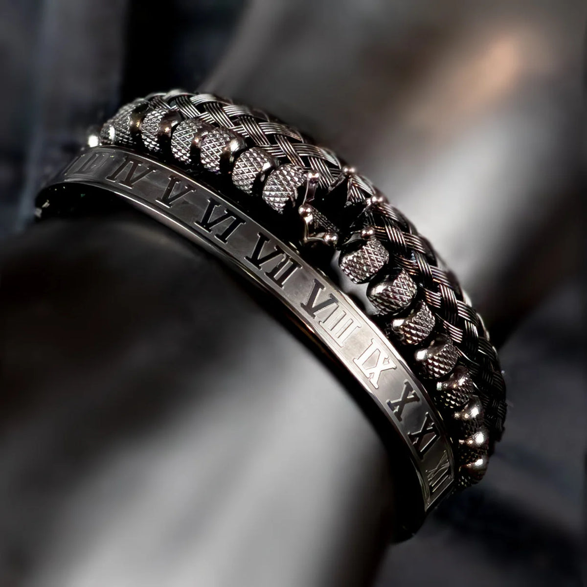 Intricately designed metallic bracelet with Roman numerals engraved on its edge.