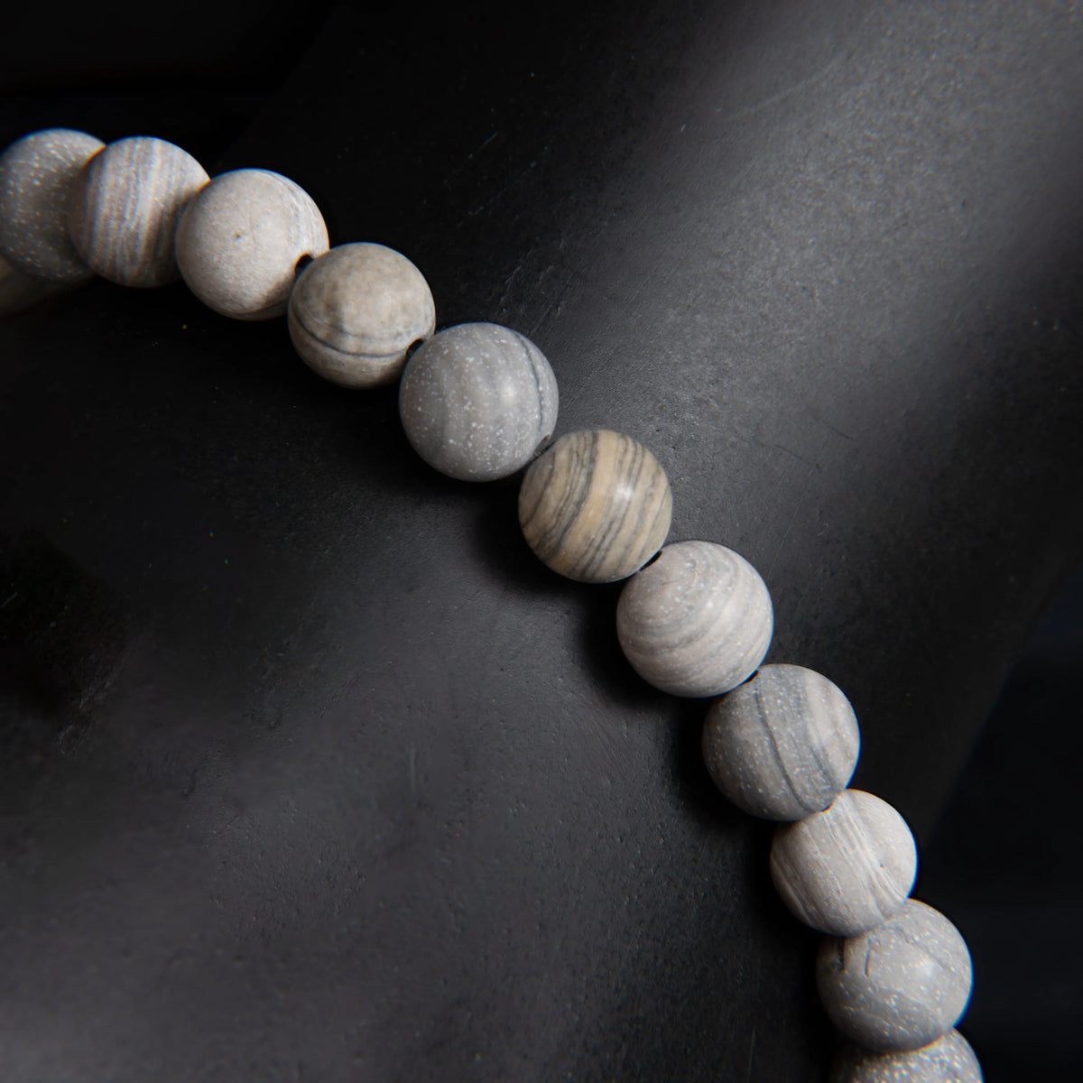 String of pale, round beads with subtle striations and variations in color.