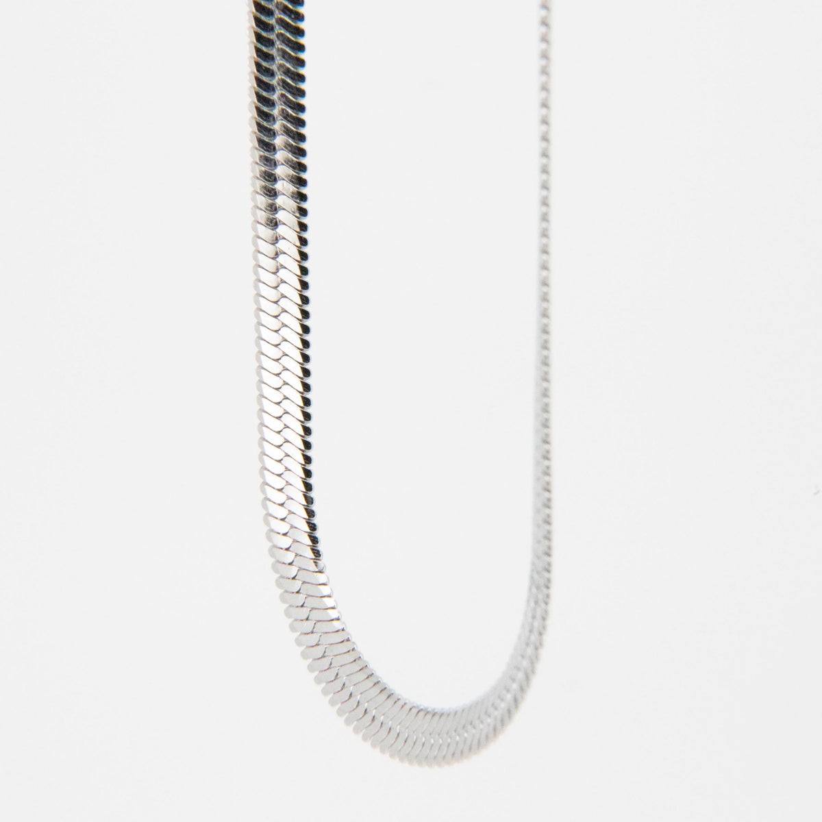 Silver snake chain necklace with flat, interlocking links.