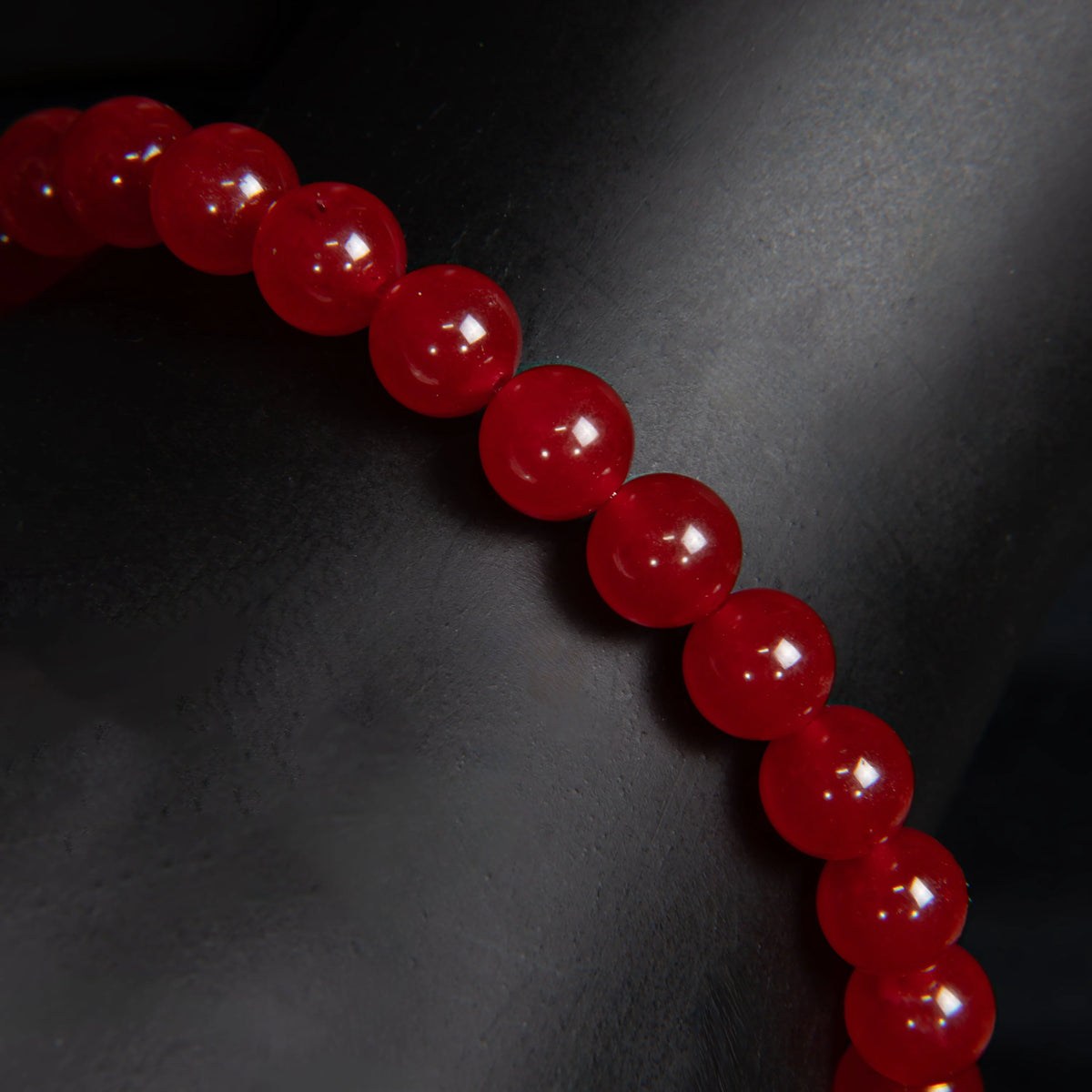 String of glossy red beads or spheres arranged in a curved line.