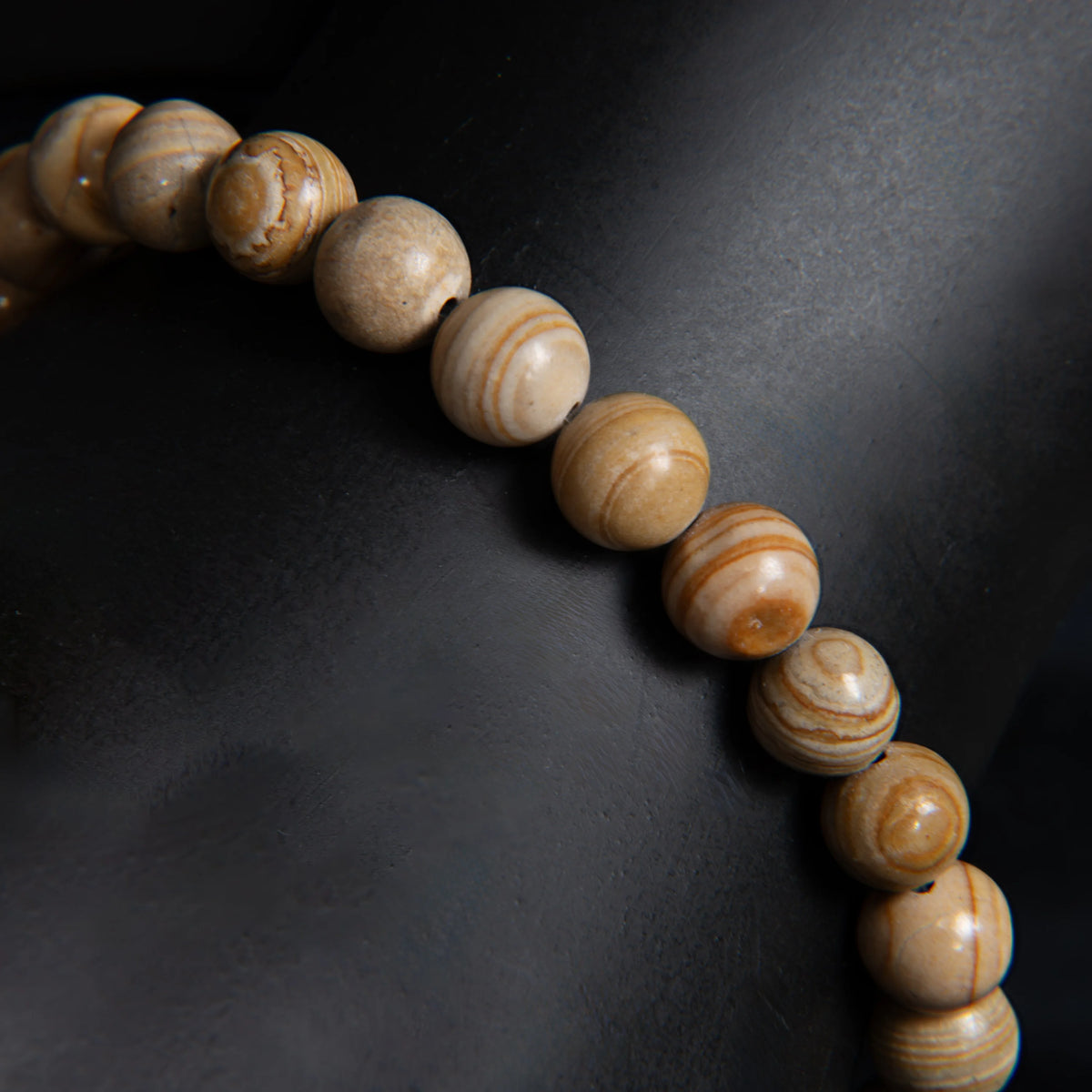 Curved line of smooth, round wooden beads with visible grain patterns.