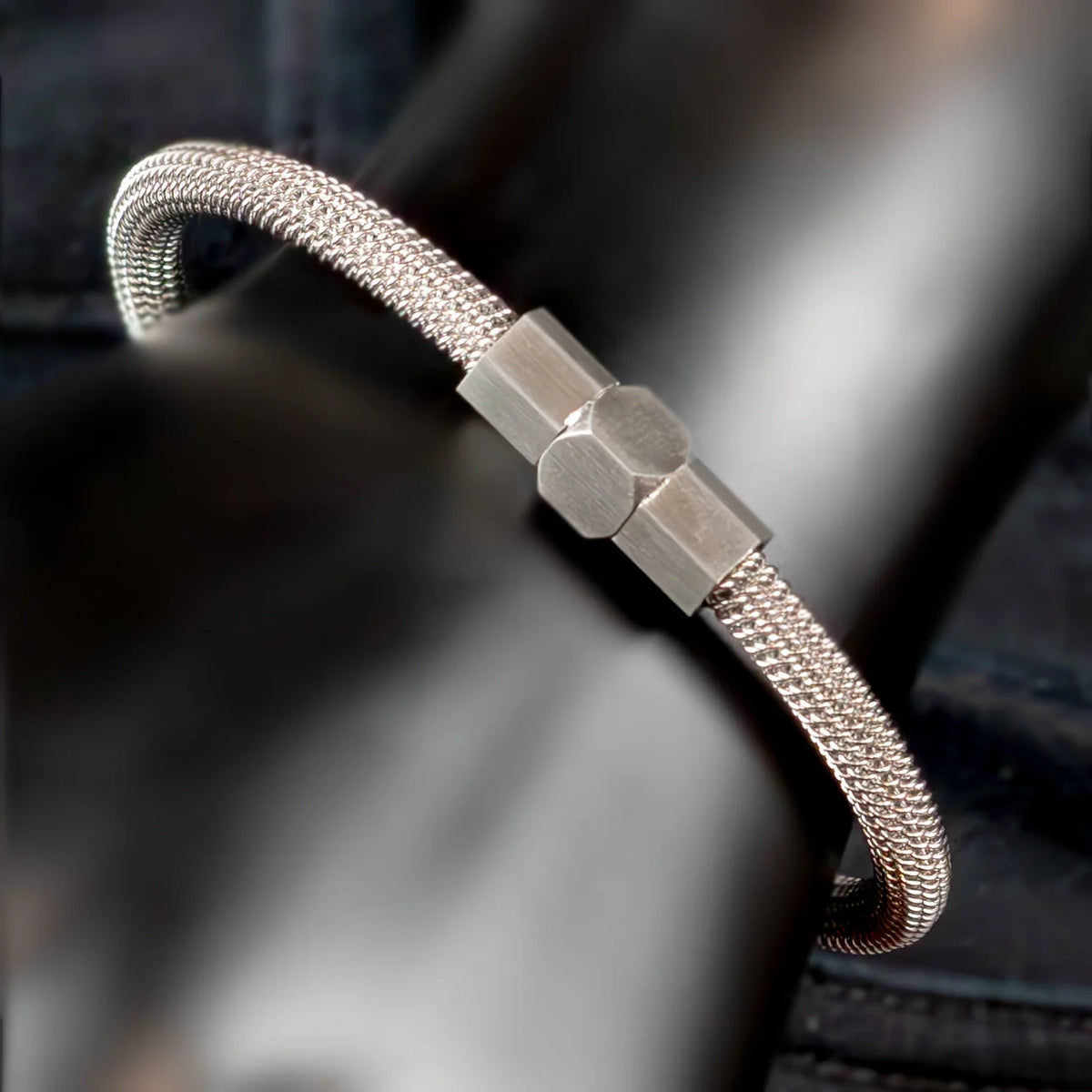 Silver mesh bracelet with a hexagonal metal clasp.