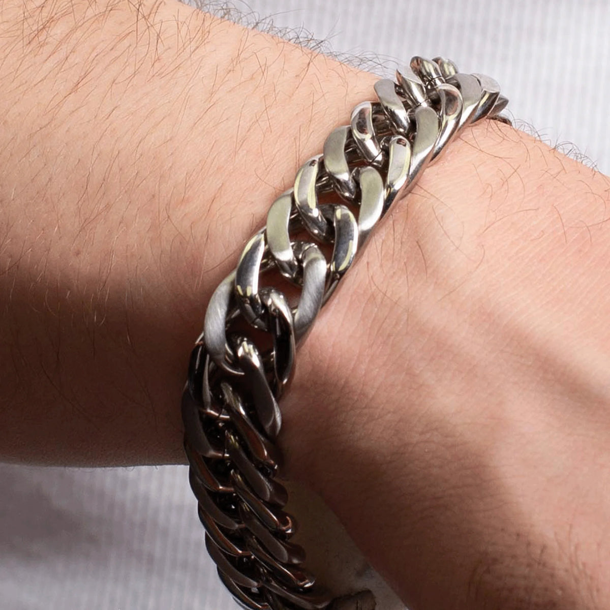 Silver chain bracelet worn on a wrist.