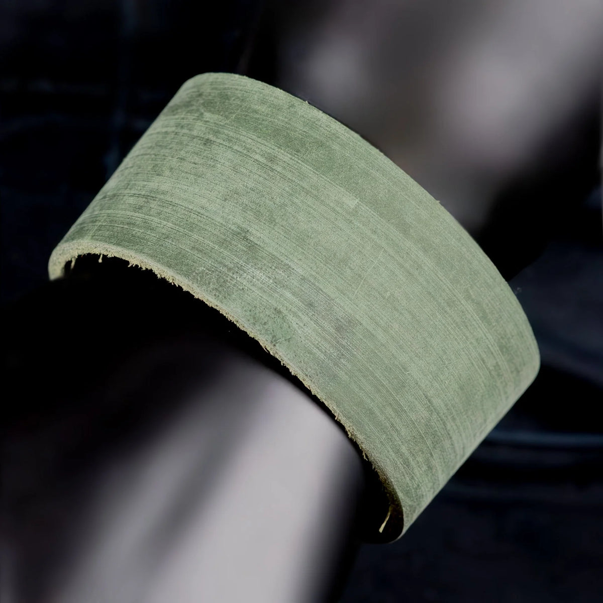 Curved piece of pale green material with a fibrous texture.