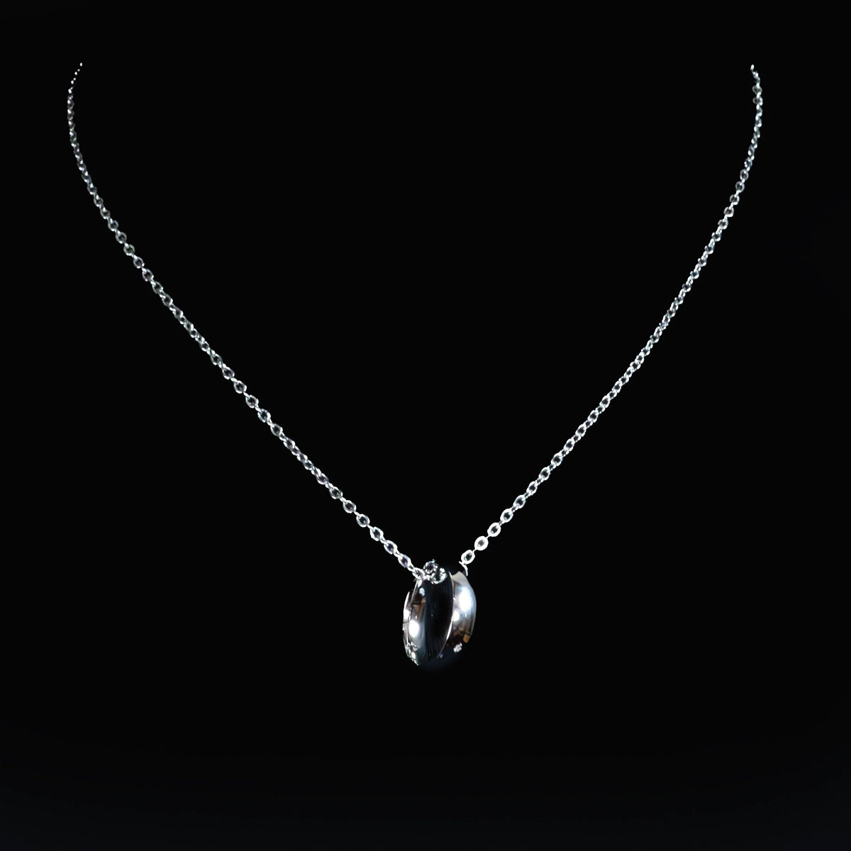 Silver necklace with two curved pendant pieces on a delicate chain.