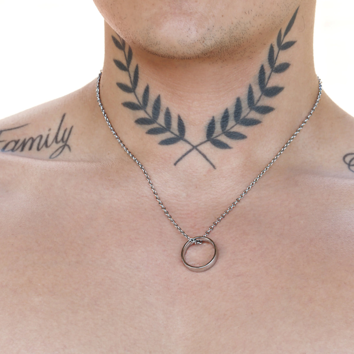 Simple silver chain necklace with a circular pendant.