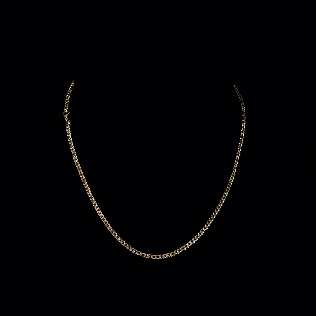 Simple gold chain necklace with a curb link design.