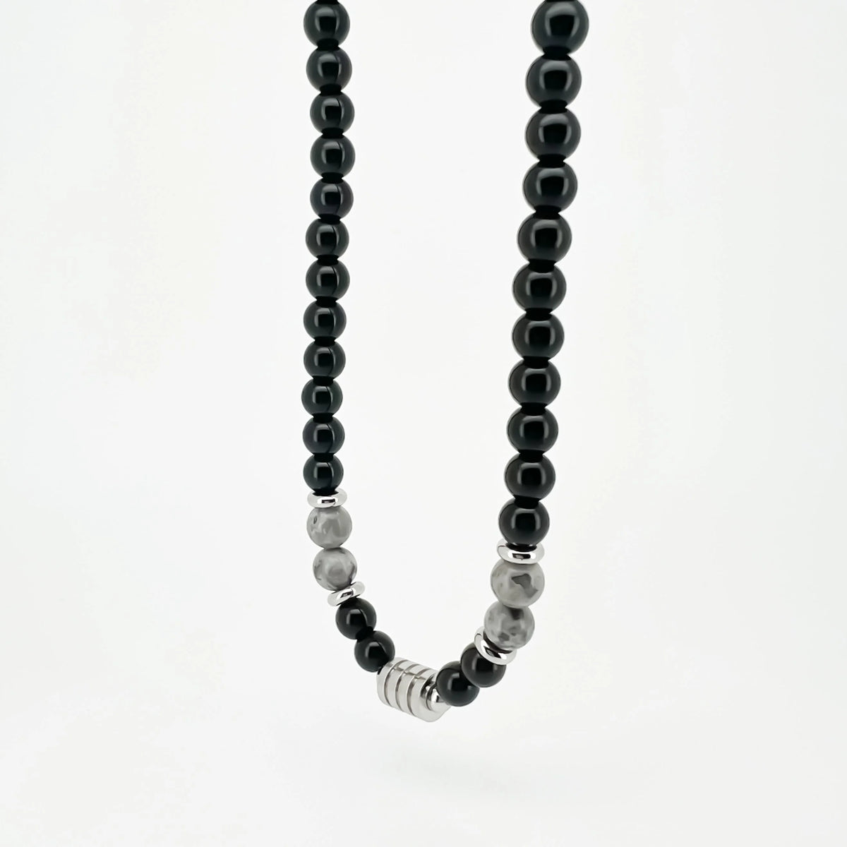 Necklace made of black and silver beads with metal rings in the center.