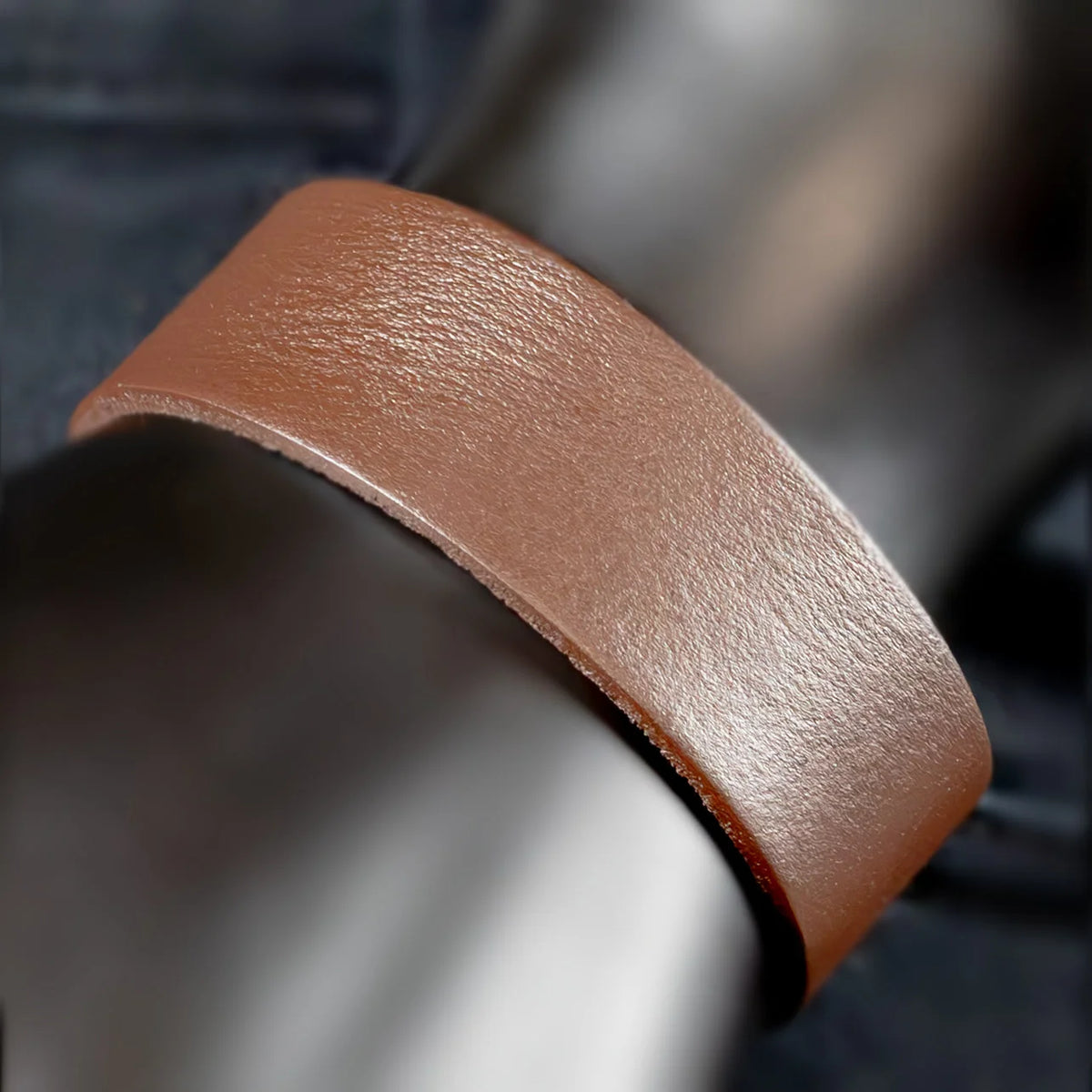 Curved strip of brown leather with a textured surface.