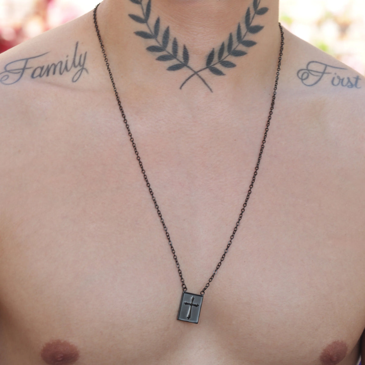 Necklace with a cross pendant hanging on a person’s chest.