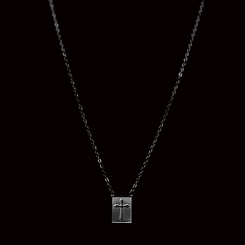 Silver necklace with a rectangular pendant featuring a cross design.