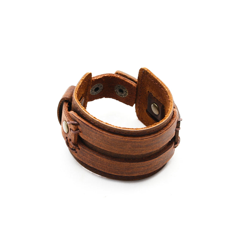 Brown leather cuff bracelet with metal studs and snap closure.