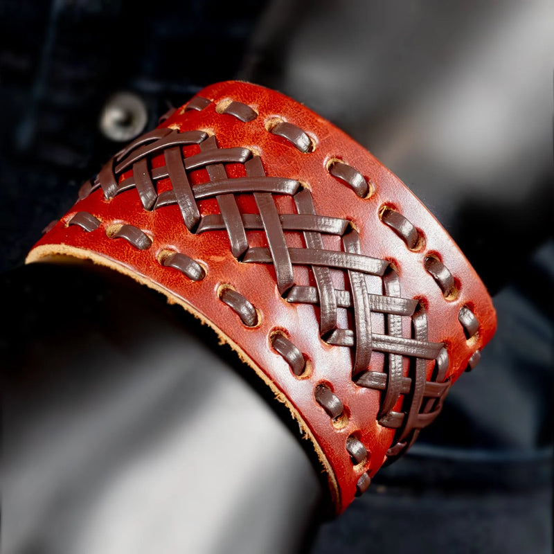 Red leather cuff bracelet with intricate woven pattern and metal studs.