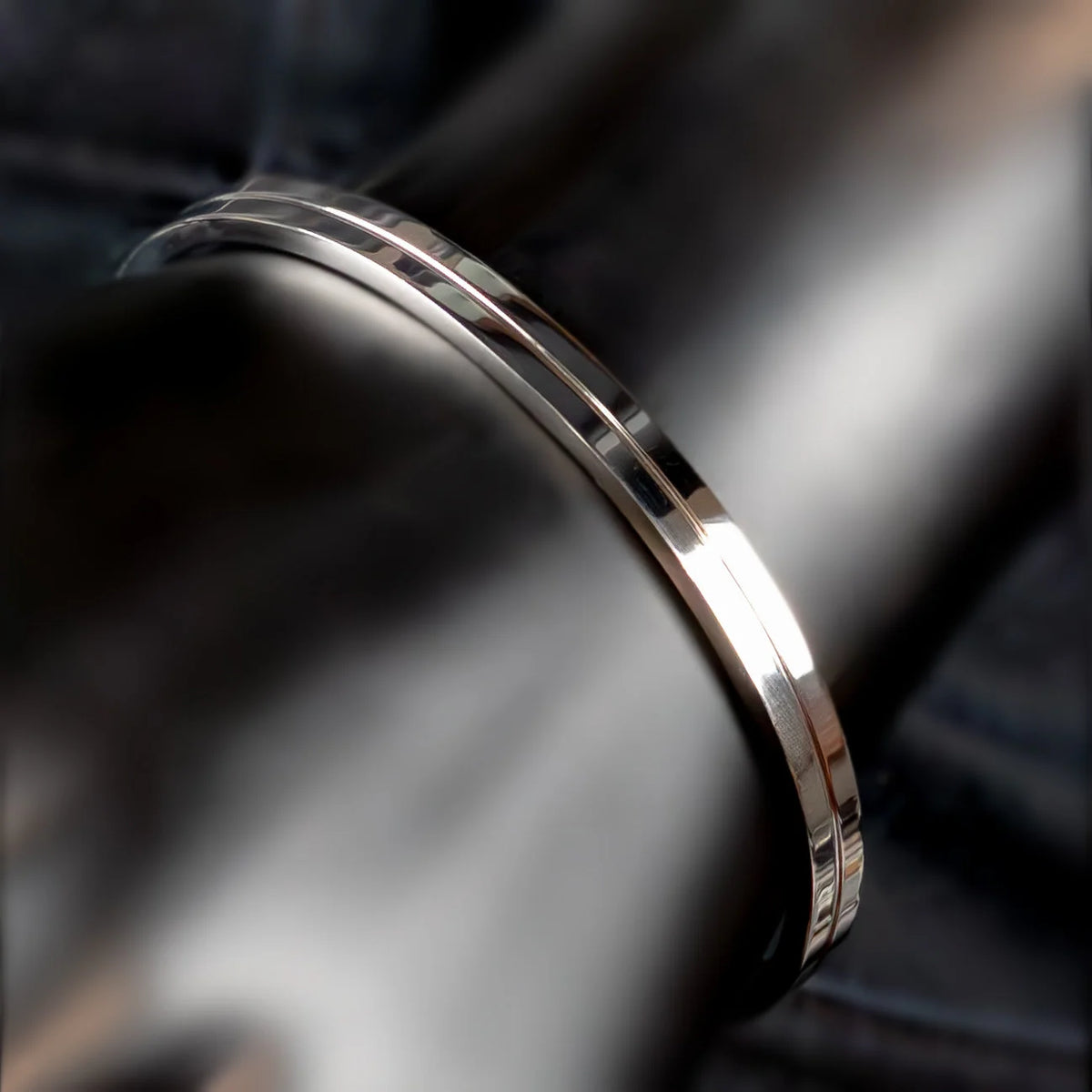 Sleek silver metal bracelet or bangle with a polished, reflective surface.