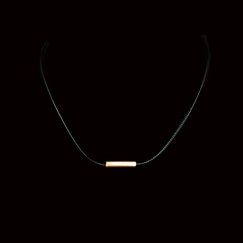 Minimalist necklace with a thin gold bar pendant on a delicate chain.