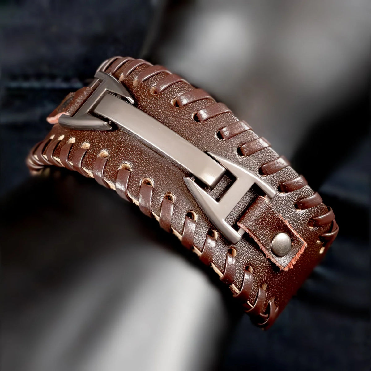 Brown leather bracelet with a metal clasp and woven design.