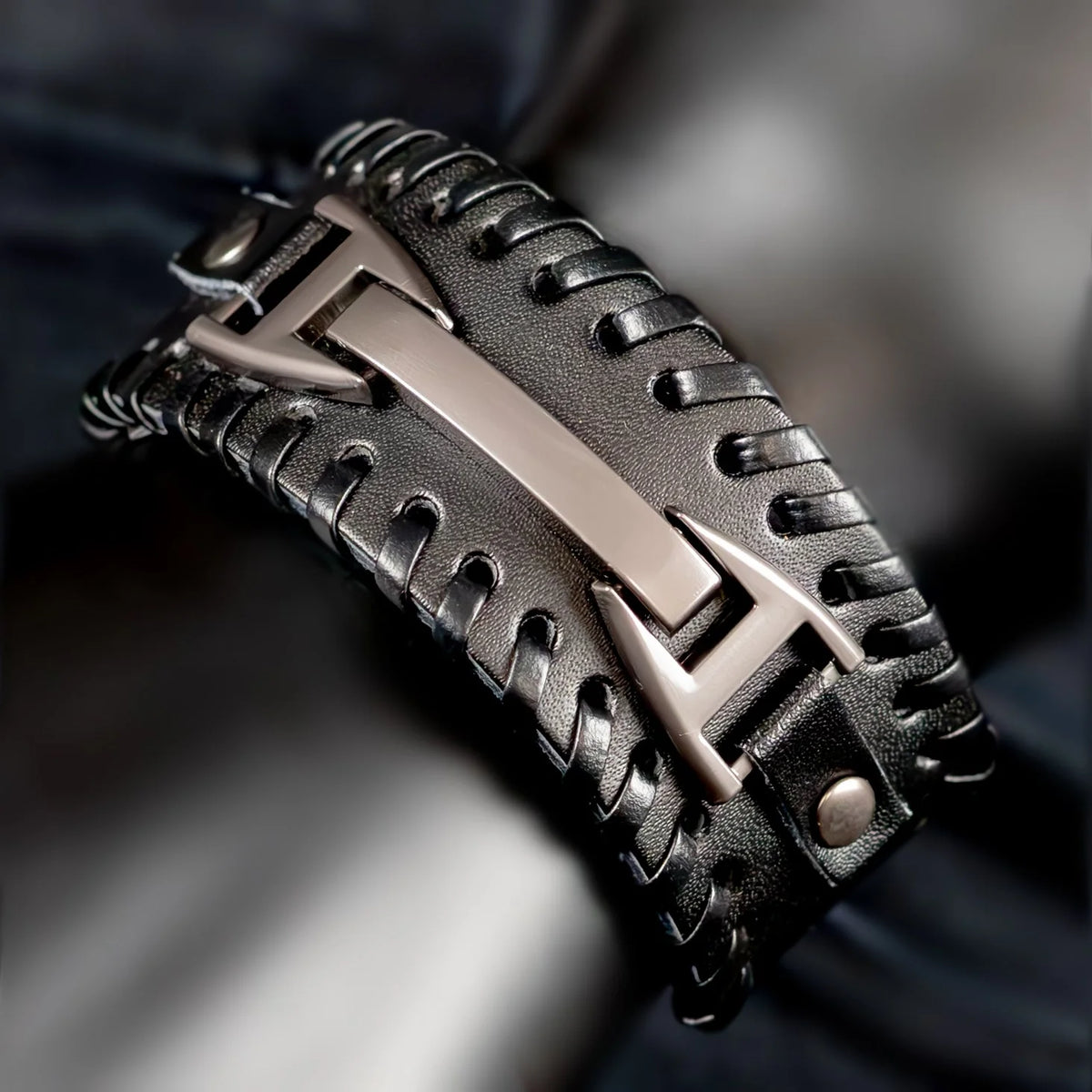 Stylish black leather bracelet with a metallic silver centerpiece.